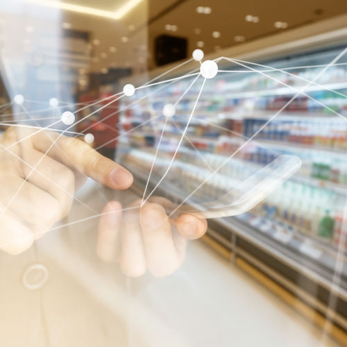 Smartphone-Nutzer in einem Supermarkt mit digitalem Netzwerk im Vordergrund.